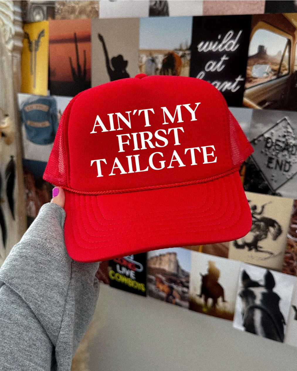 Red cap with 'Ain't my first tailgate' text held in front of a collage of photos.