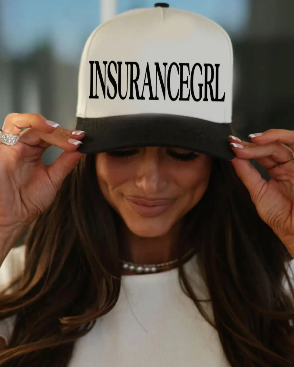 Person wearing a cap with 'INSURANCEGIRL' text