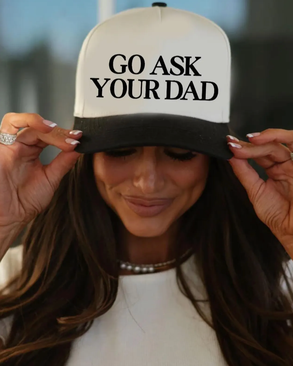 Person wearing a cap with 'GO ASK YOUR DAD' text