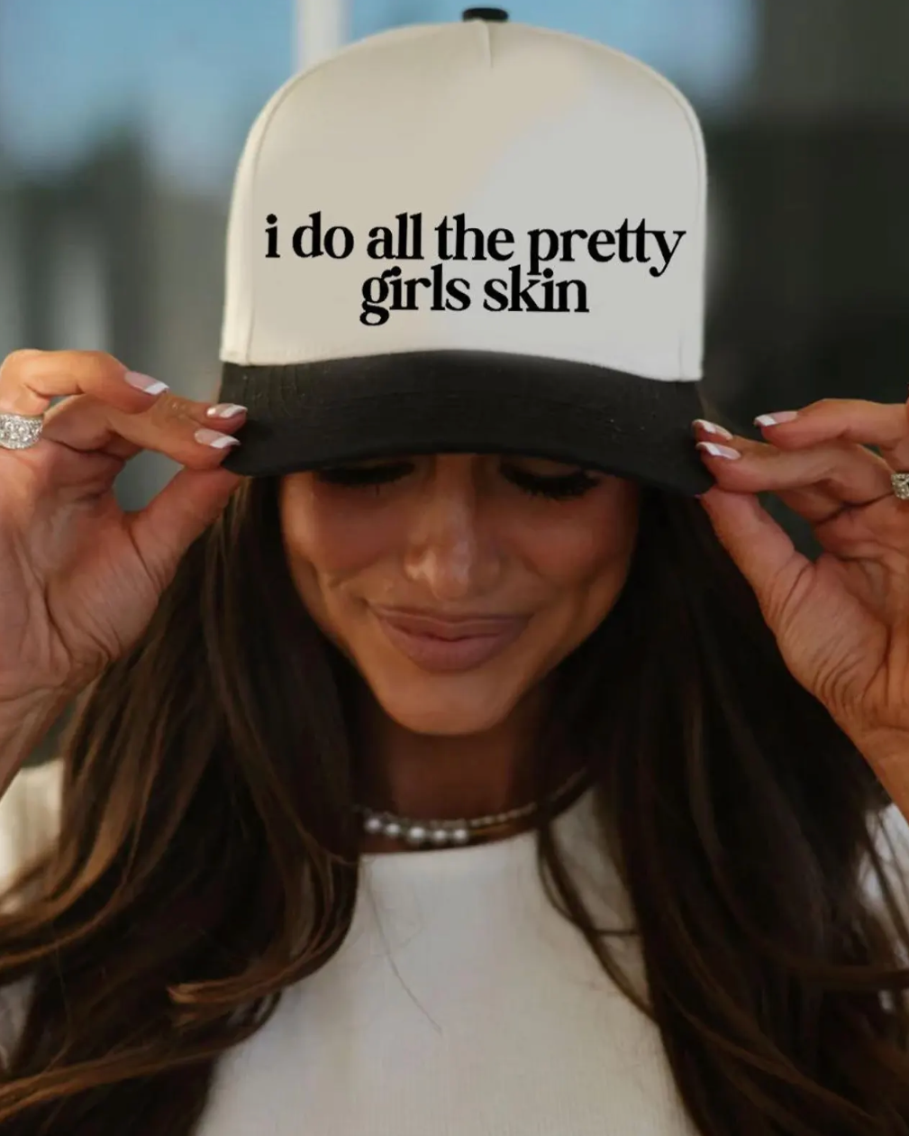 Person wearing a cap with 'i do all the pretty girls skin' text